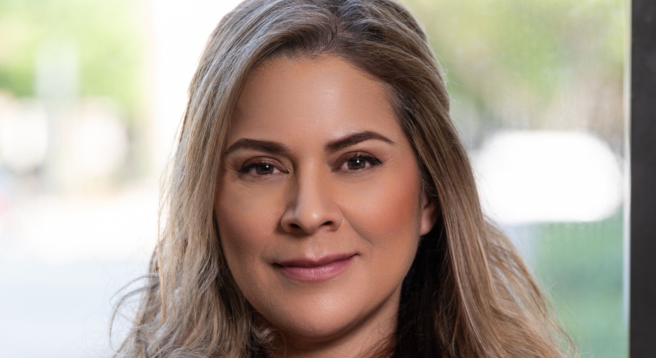 Portrait of a woman smiling indoors.