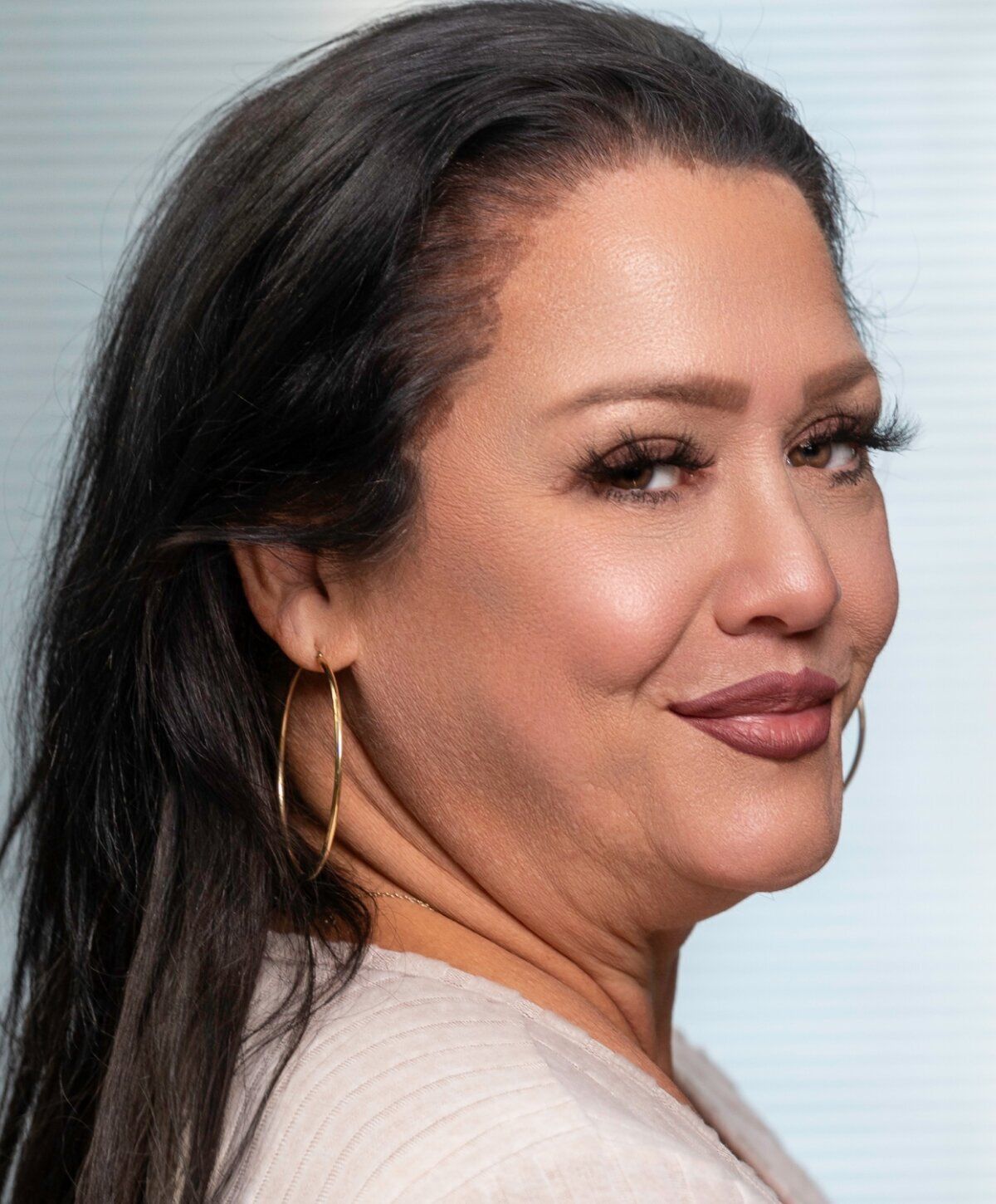 Woman with long hair smiling sideways.