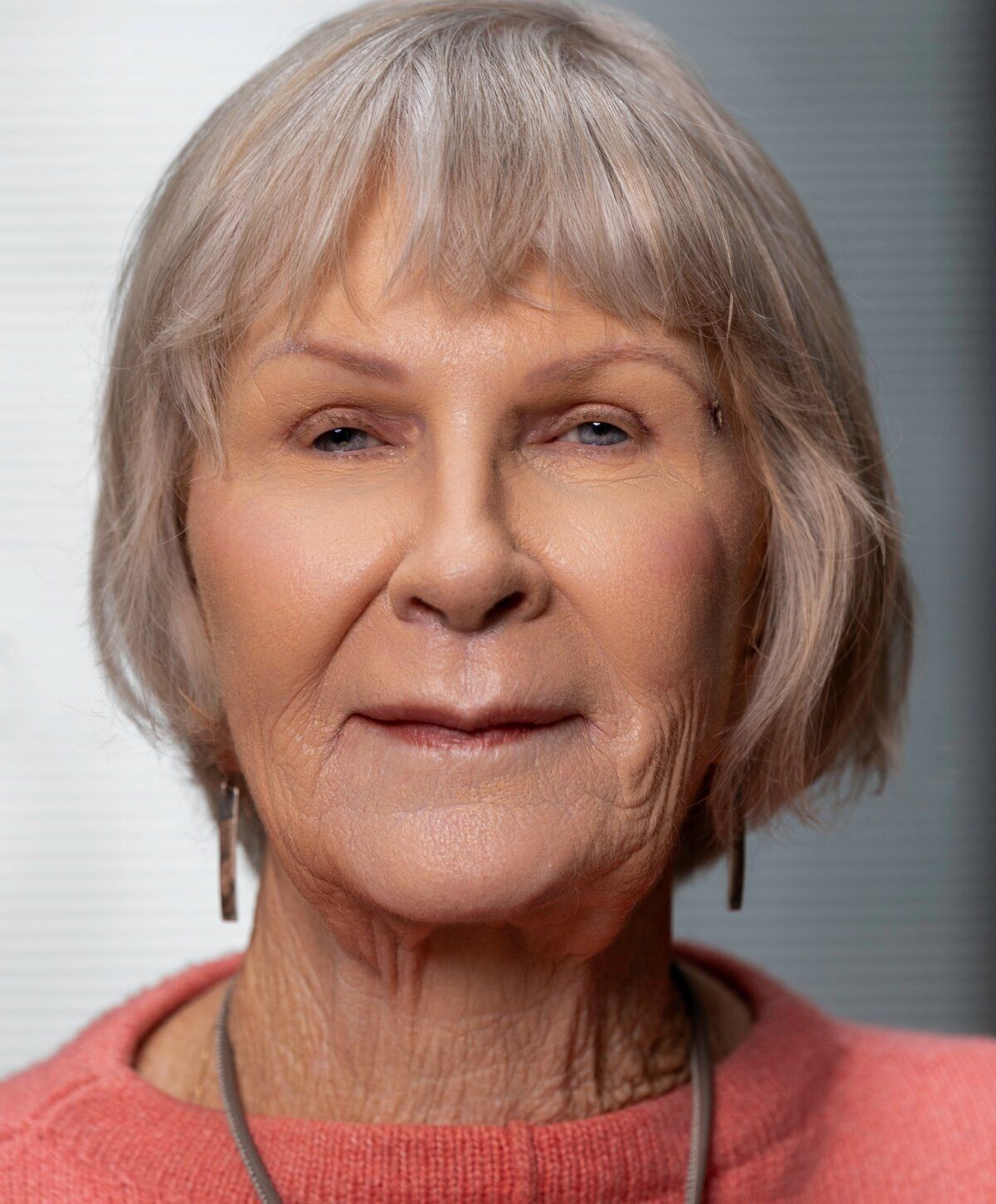 Elderly woman with short light gray hair.