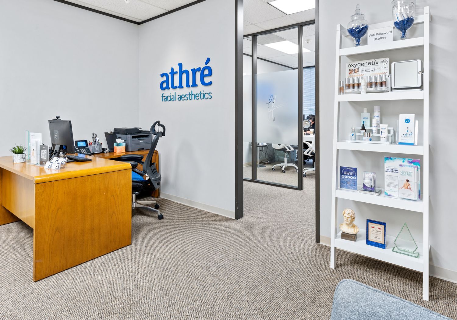 Facial aesthetics office with products and desk.