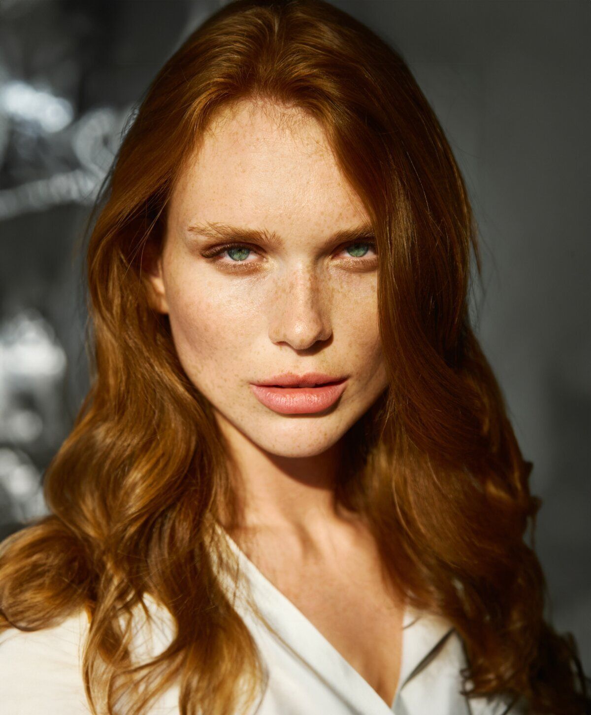 Woman with red hair and striking green eyes.