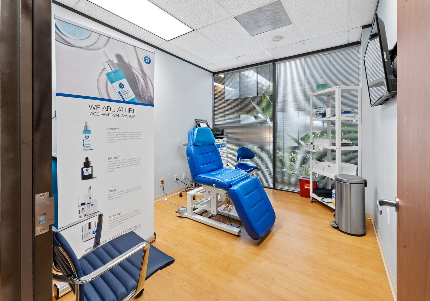 Medical treatment room with blue chairs and banner.