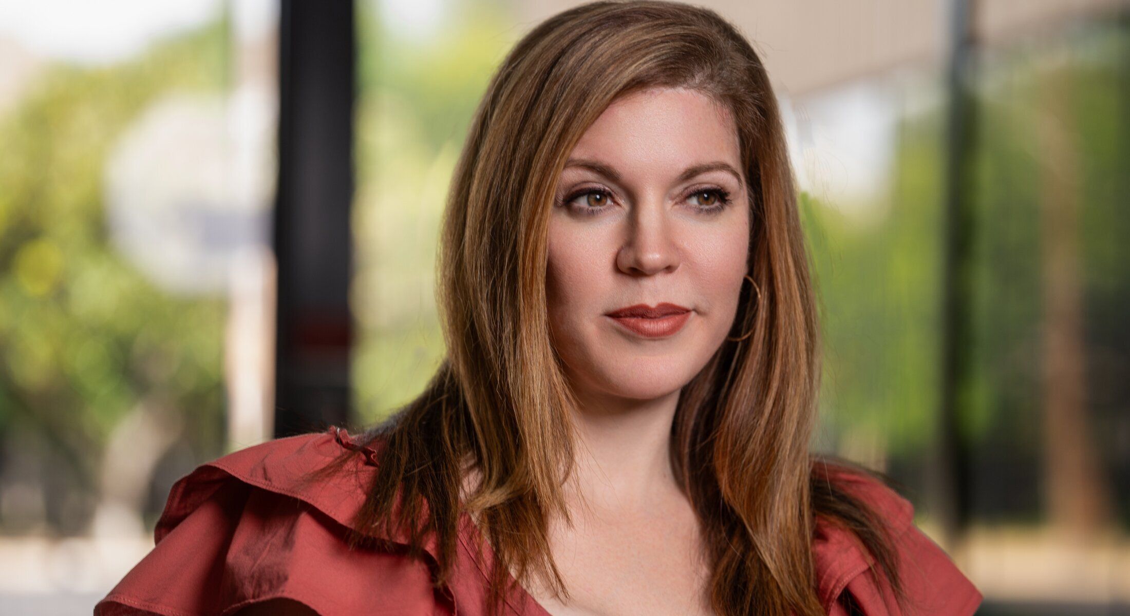 Woman with long hair in a red blouse.