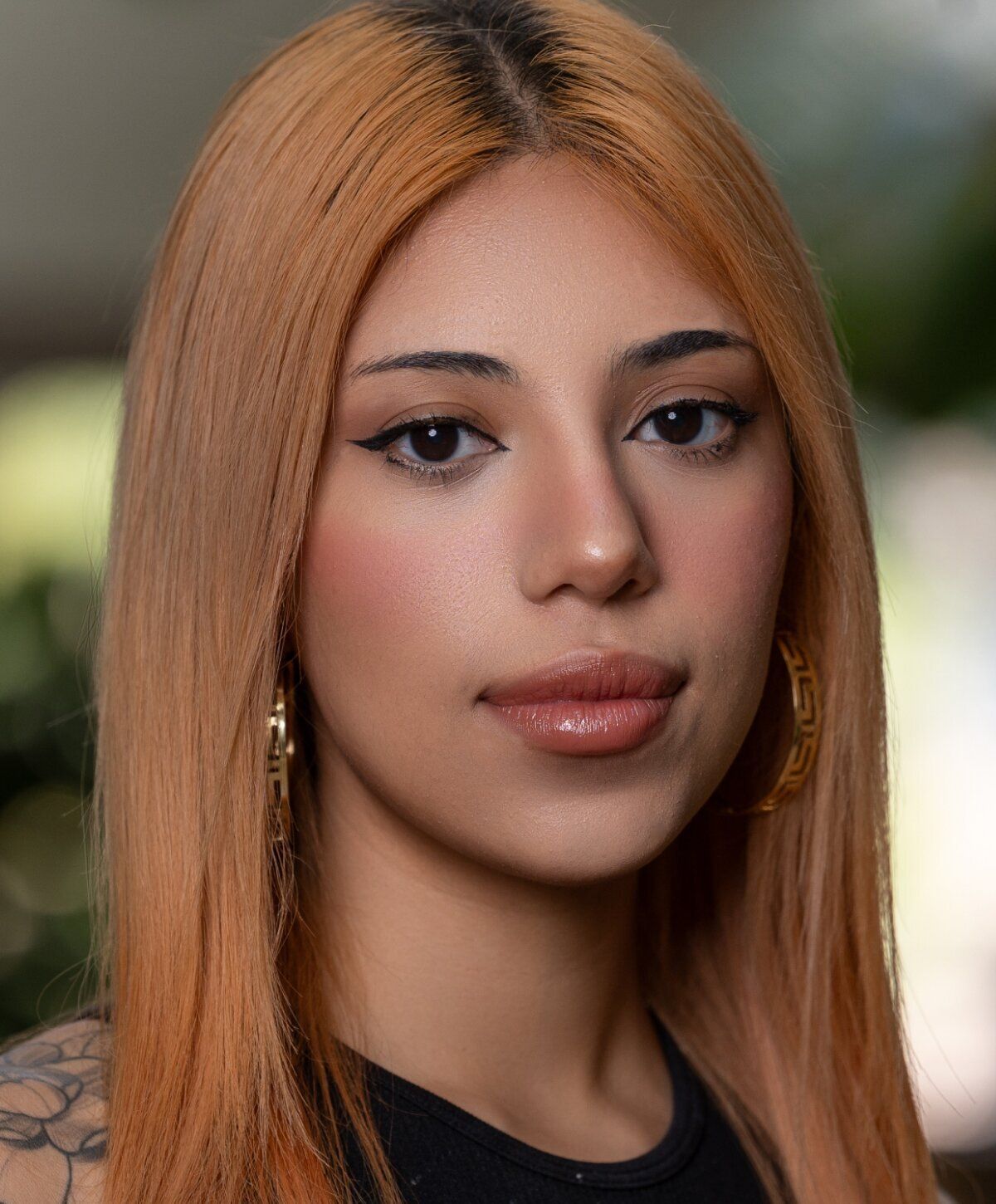 Young woman with long orange hair and earrings.