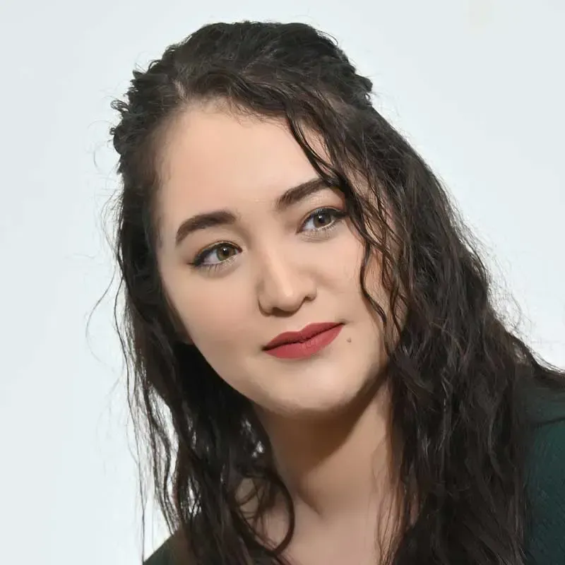 Young woman with curly hair and natural makeup.