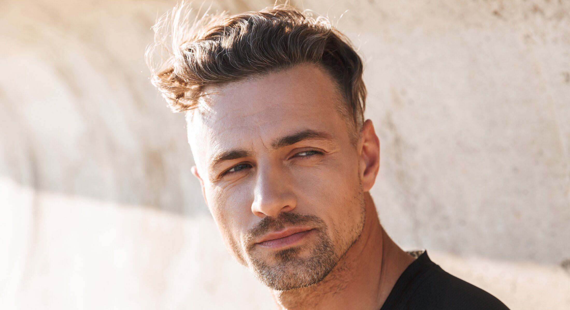 Close-up of man with stylish haircut and beard.