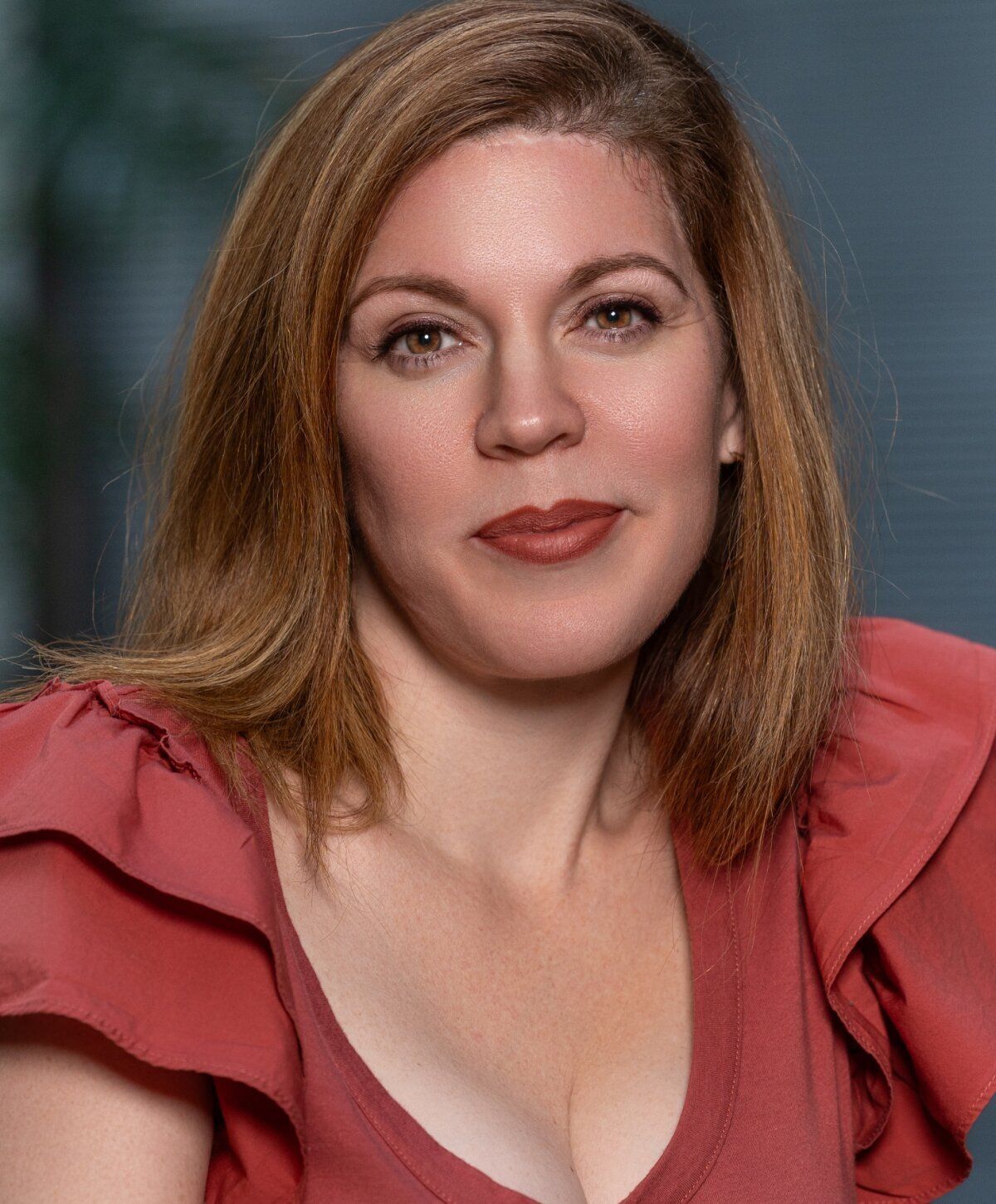 Woman with brown hair in a red blouse.