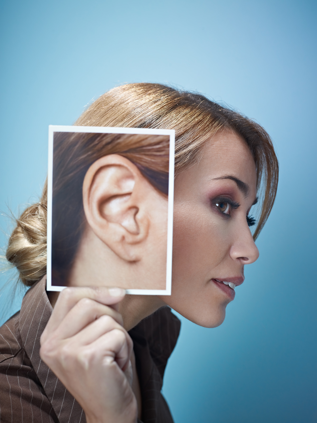 woman holding a photo of an ear
