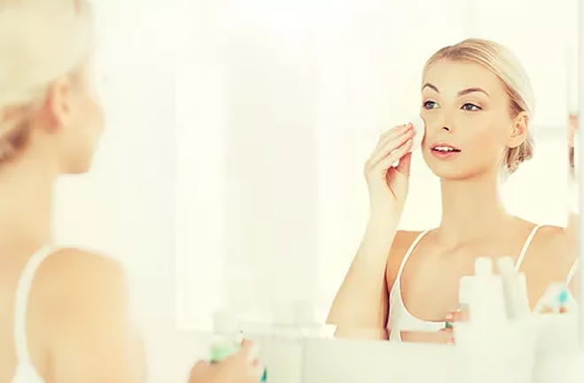 woman washing face in mirror