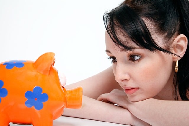 woman looking worried at a piggy bank