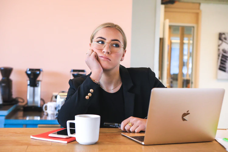 woman in front of open laptop looking frustrated