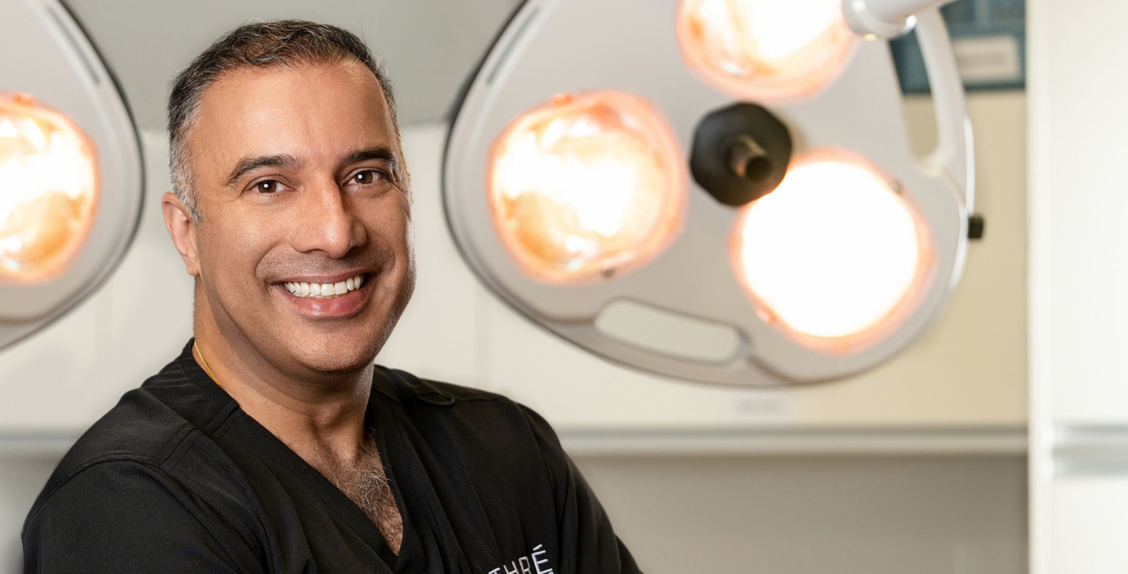 Smiling medical professional in a surgical setting.