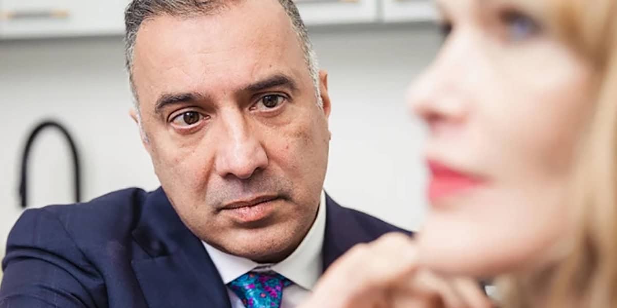 Dr. Raghu Athré evaluating a patient's facial profile during a consultation